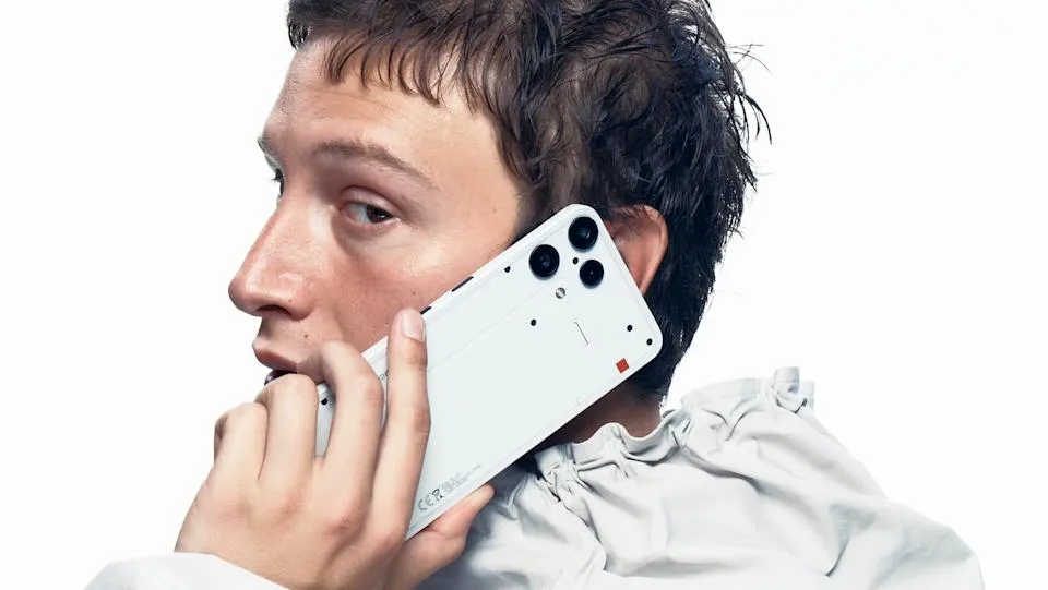 Marketing phone for the Nothing Phone 3a Lite. A suave-looking person holds the phone while on a call, looking nonchalantly over their shoulder toward the camera.